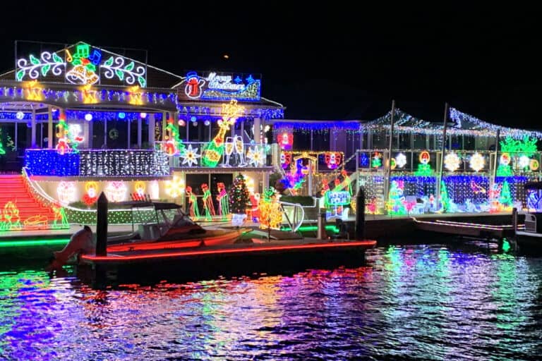 Christmas Lights Cruise passing a brightly lit canal home in Mandurah